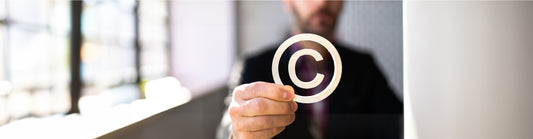 Man holding a copyright symbol in focus, representing intellectual property and copyright protection.